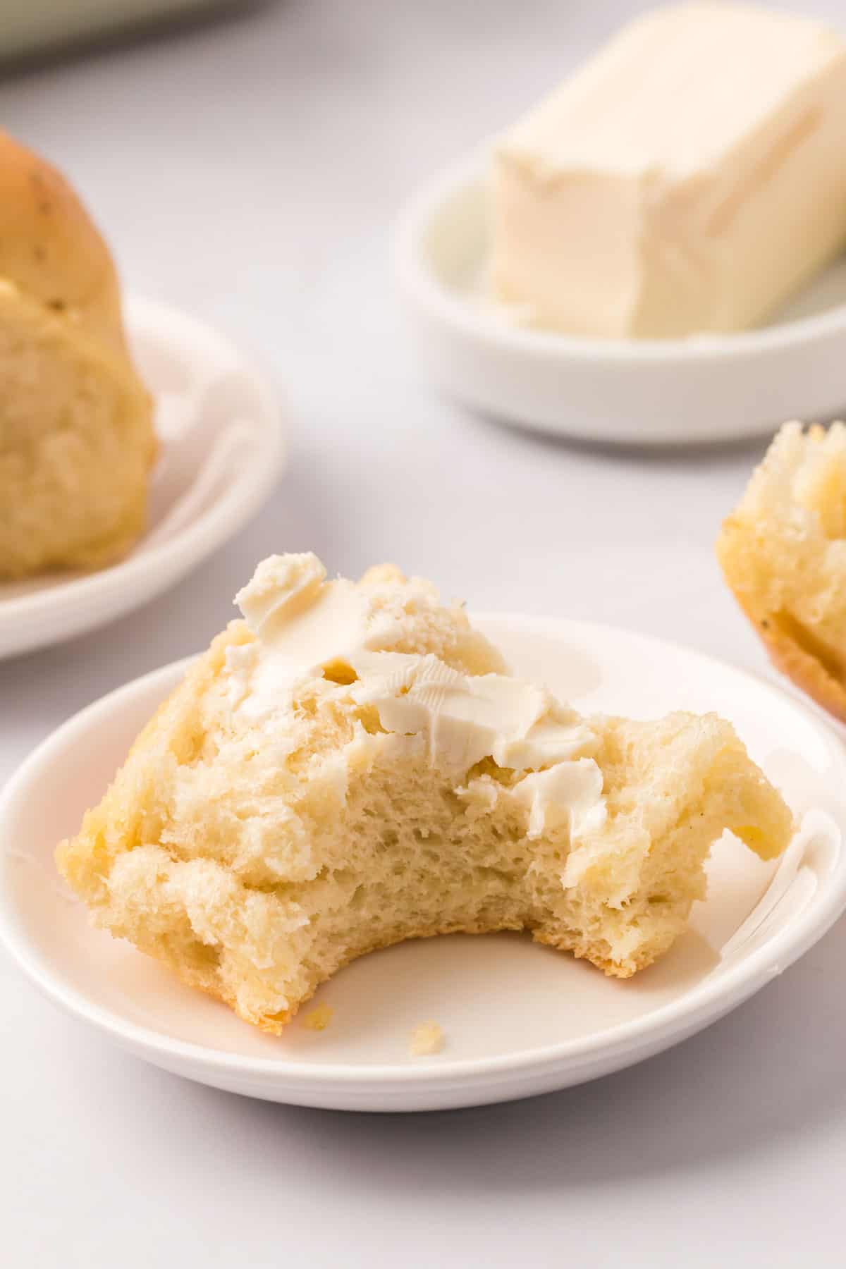 A dinner roll sliced open and slather with softened butter.