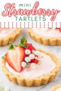 A close-up photo of mini strawberry tartlets with golden Oreo shells, filled with creamy strawberry filling and topped with fresh strawberries.