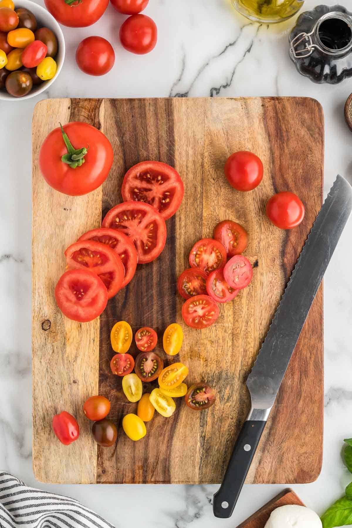 Sliced tomatoes on a wooden cutting board.