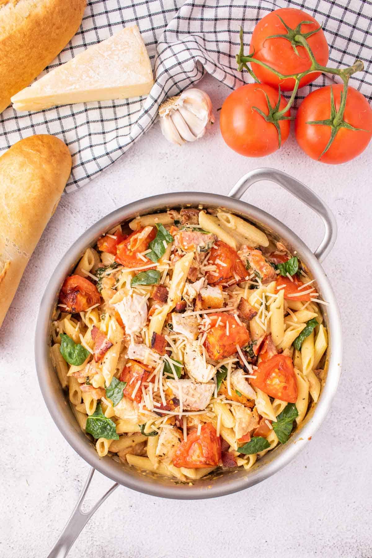 Chicken and bacon pasta in a stainless steel pot.