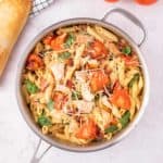 Chicken and bacon pasta in a stainless steel pot.