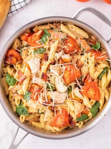 Chicken and bacon pasta in a stainless steel pot.