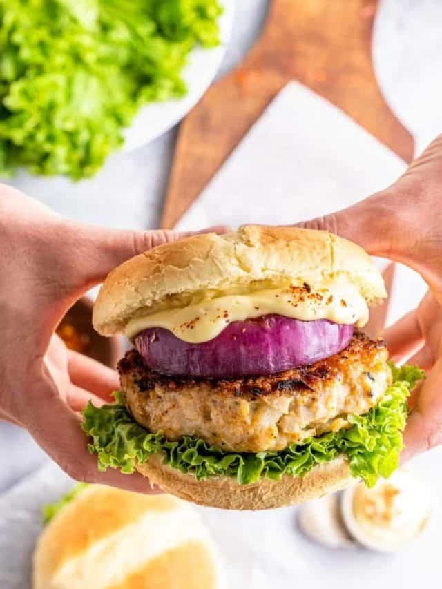 Hands holding a juicy good ground chicken burger pinterest image pin 4.