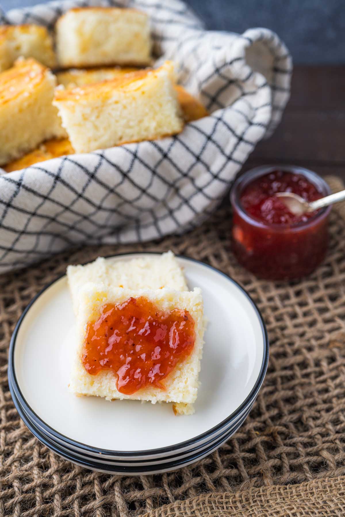 A sliced butter swim biscuit with strawberry jelly slathered on it.