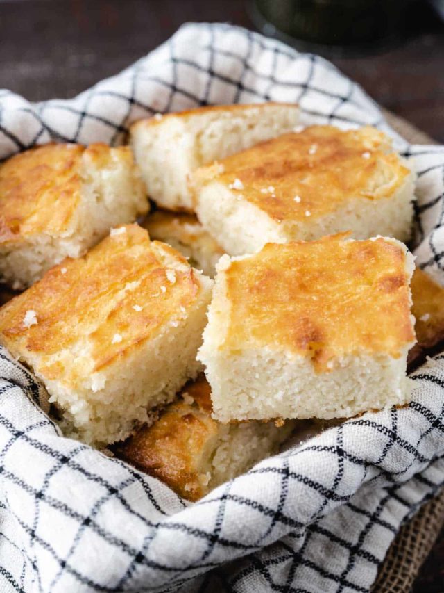 A basket with a tea towel full of sliced butter dip biscuits.