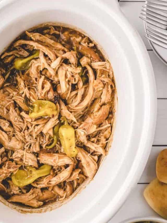 Mississippi Chicken with pepperoncinis in a white slow cooker bowl and set on the table to serve.