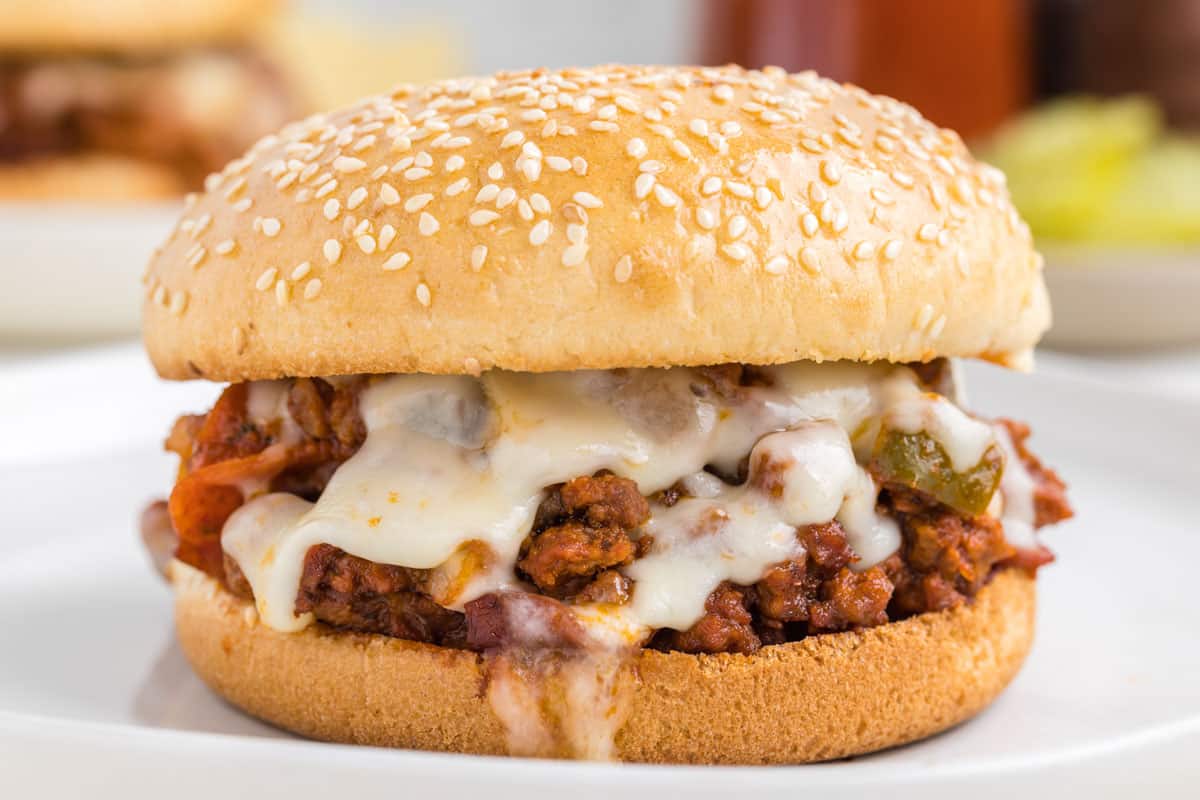 A pizza sloppy joe with melted mozzarella on a toasted sesame seed bun.