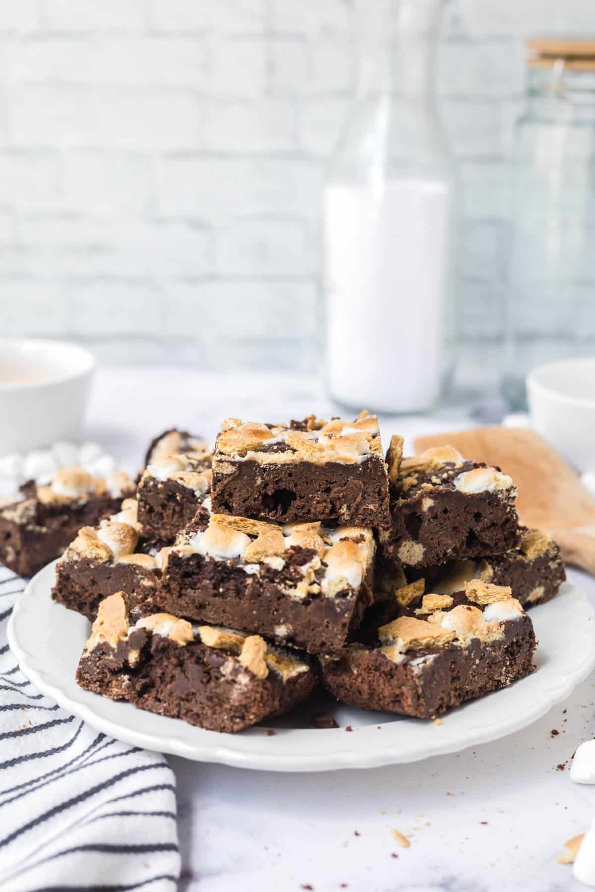 A white plate stacked with sliced s'mores brownies.