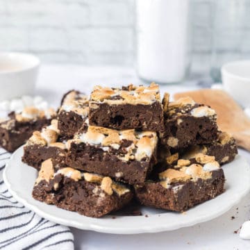 A white plate stacked with sliced s'mores brownies.