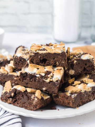 A white plate stacked with sliced s'mores brownies.