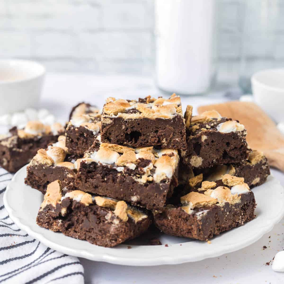 A white plate stacked with sliced s'mores brownies.