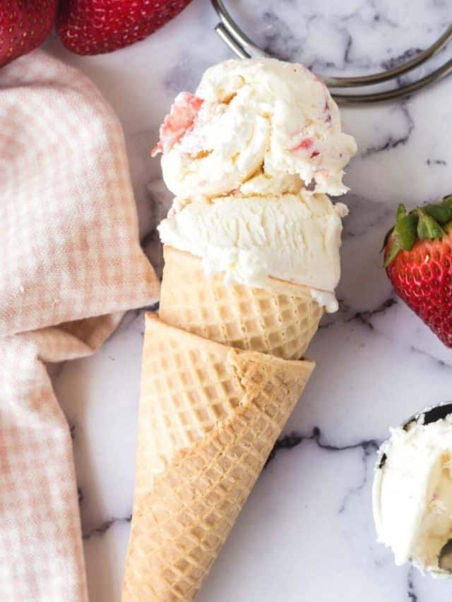 A waffle cone filled with two scoops of strawberry ice cream.
