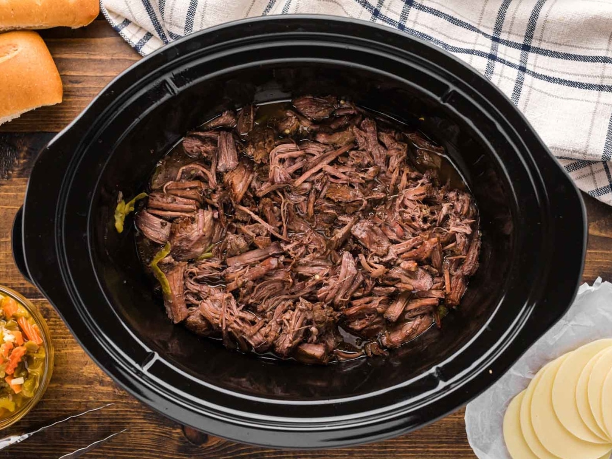 Shredded Italian Beef in a black crock pot.