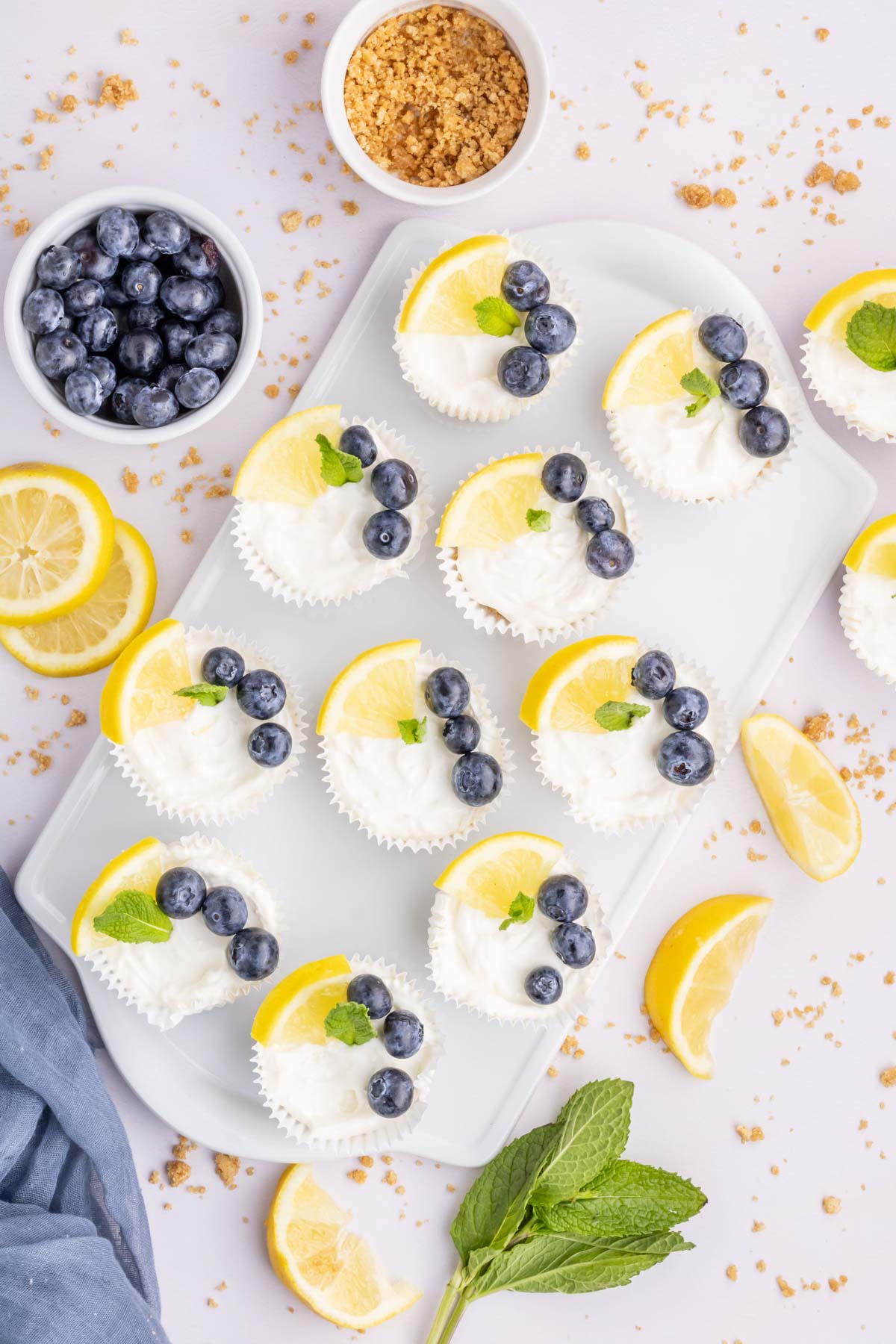 A white tray filled with lemon cheesecake cupcakes.