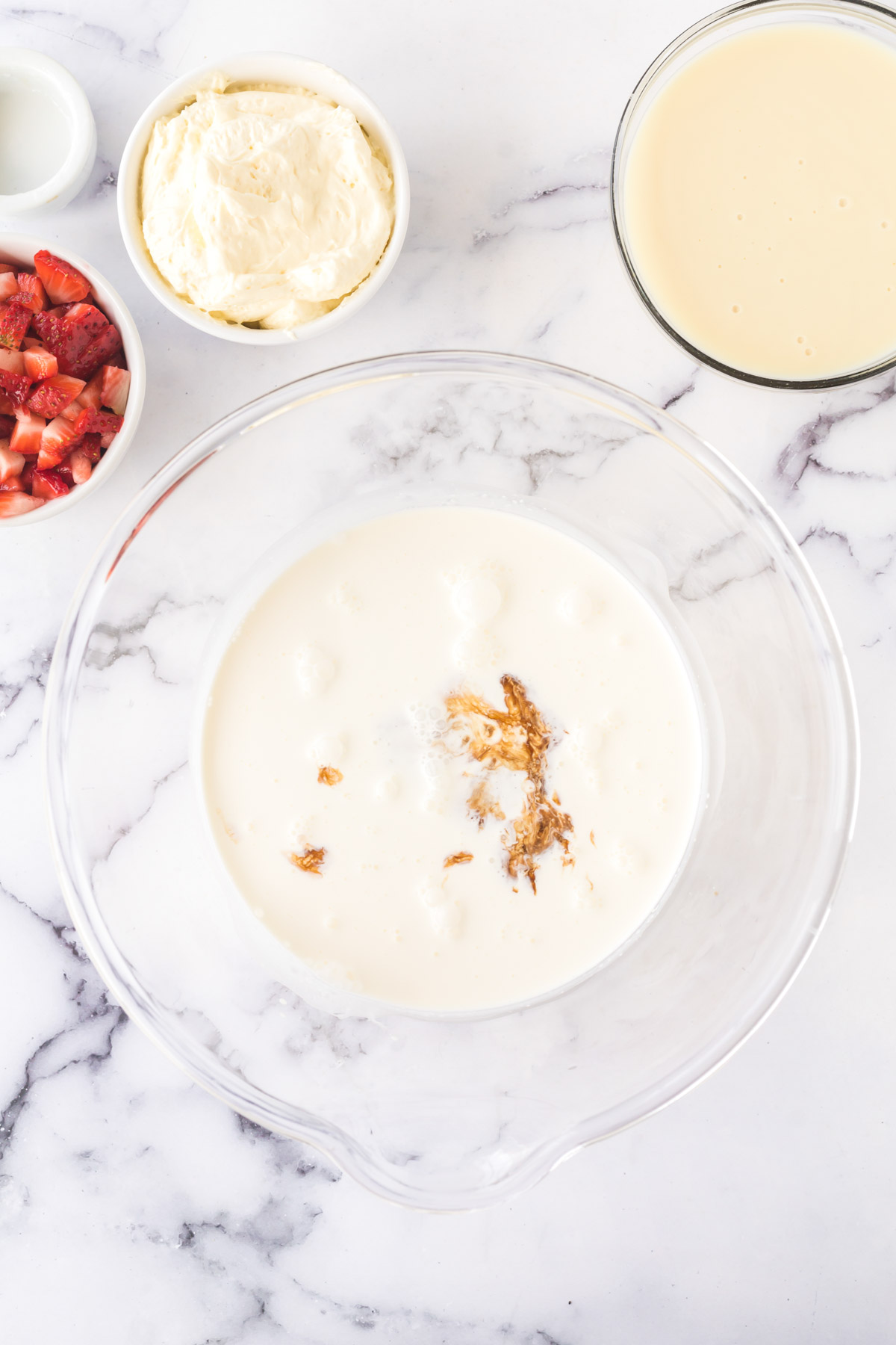 Heavy whipping cream and vanilla extract in a bowl.