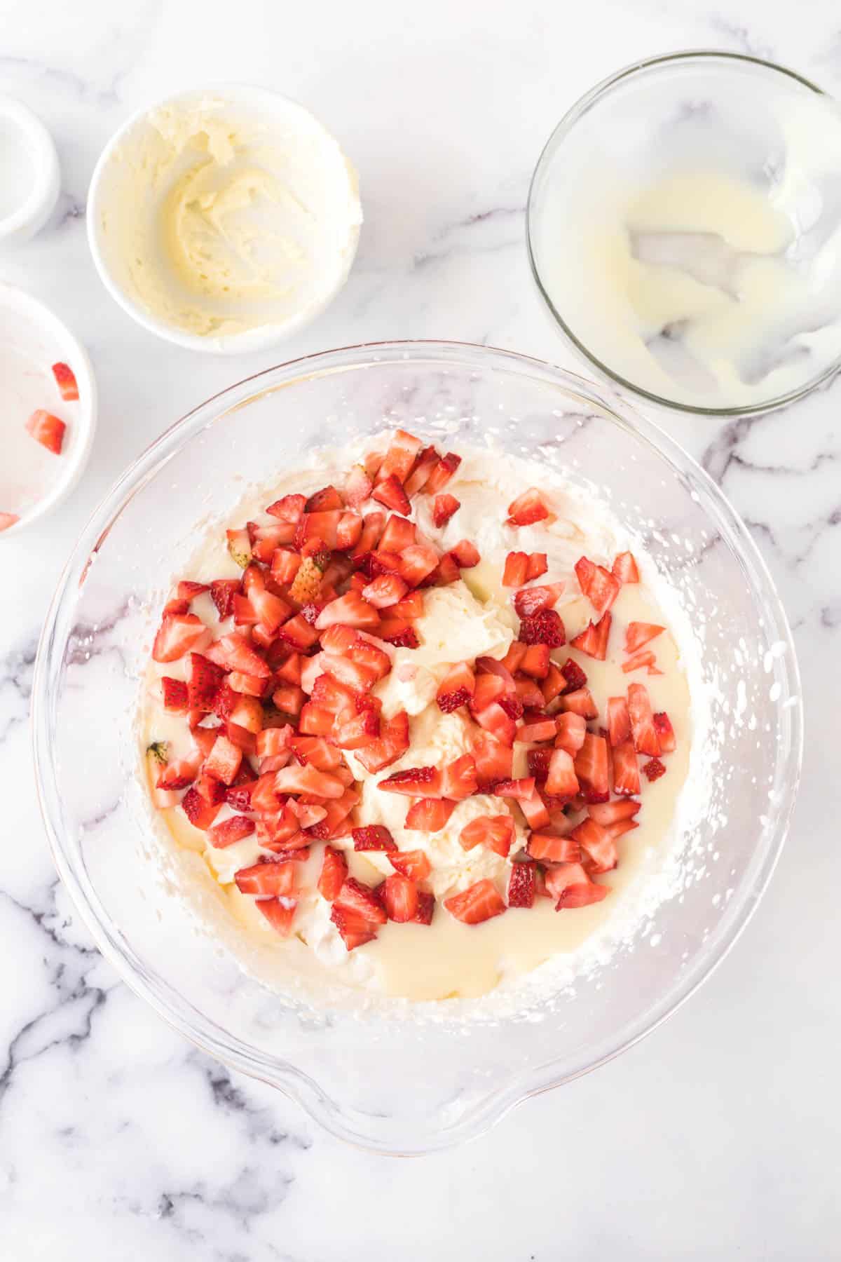 Diced strawberries added to ice cream mixture.