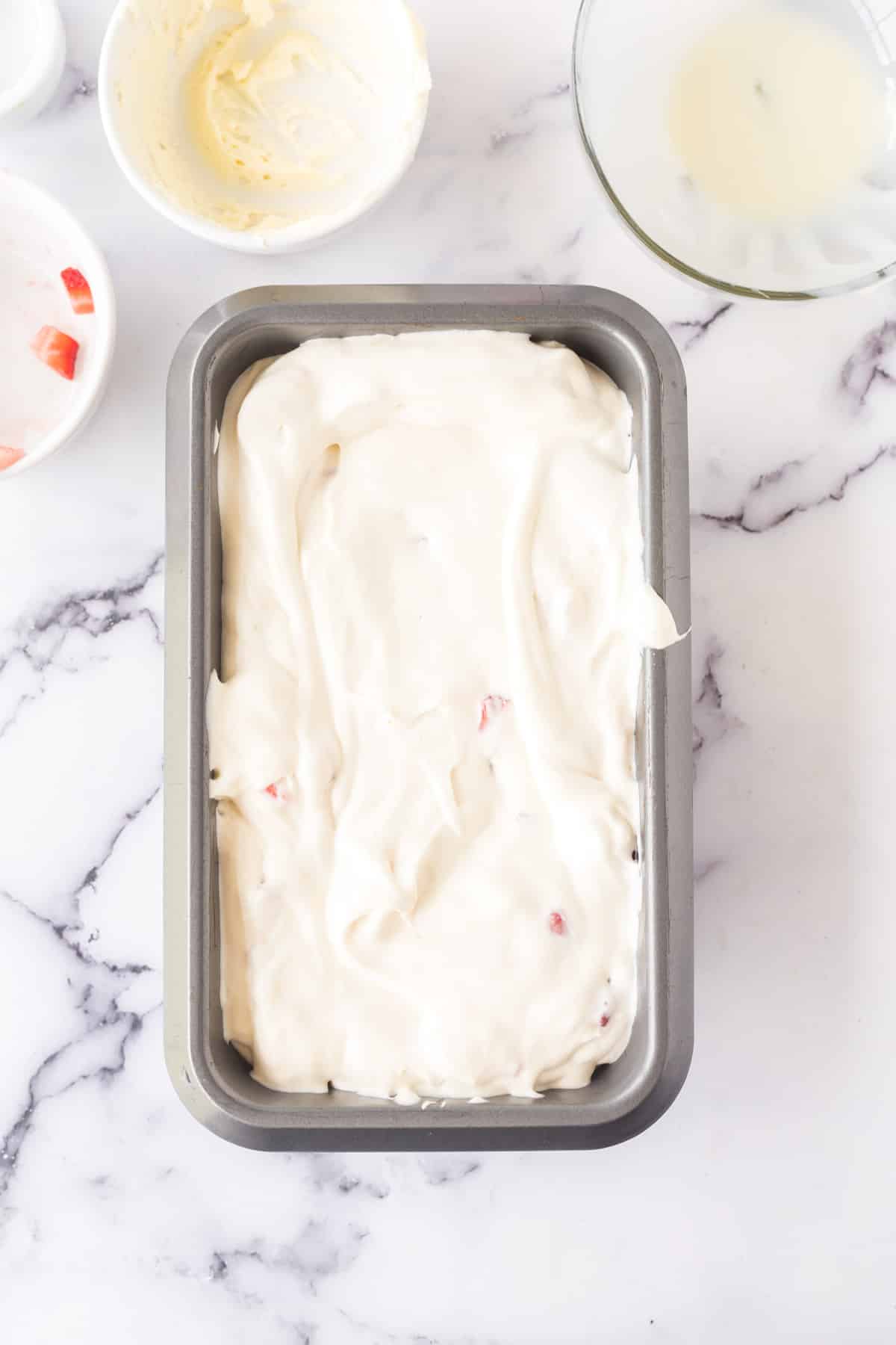 No-Churn strawberry cheesecake ice cream mixture in a loaf pan.