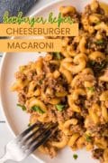 A white dinner plate is filled with the hamburger helper cheeseburger macaroni with a fork ready on the side of the plate.