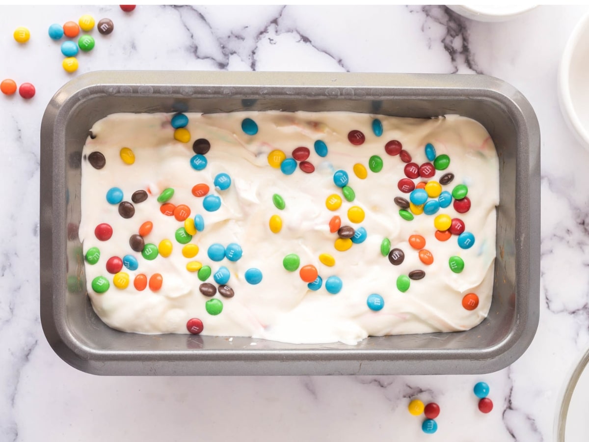 M&M Ice Cream mixture added to 9X5 loaf pan to freeze for no-churn ice cream.