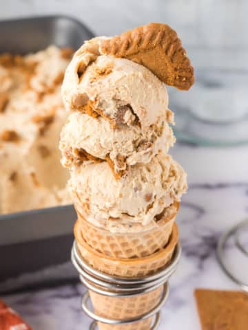 A waffle cone filled with no-churn biscoff ice cream garnished with a cookie.