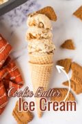 A picture featuring a cake cone filled with 4 scoops piled high of Cookie Butter Ice Cream and Biscoff cookies all around.