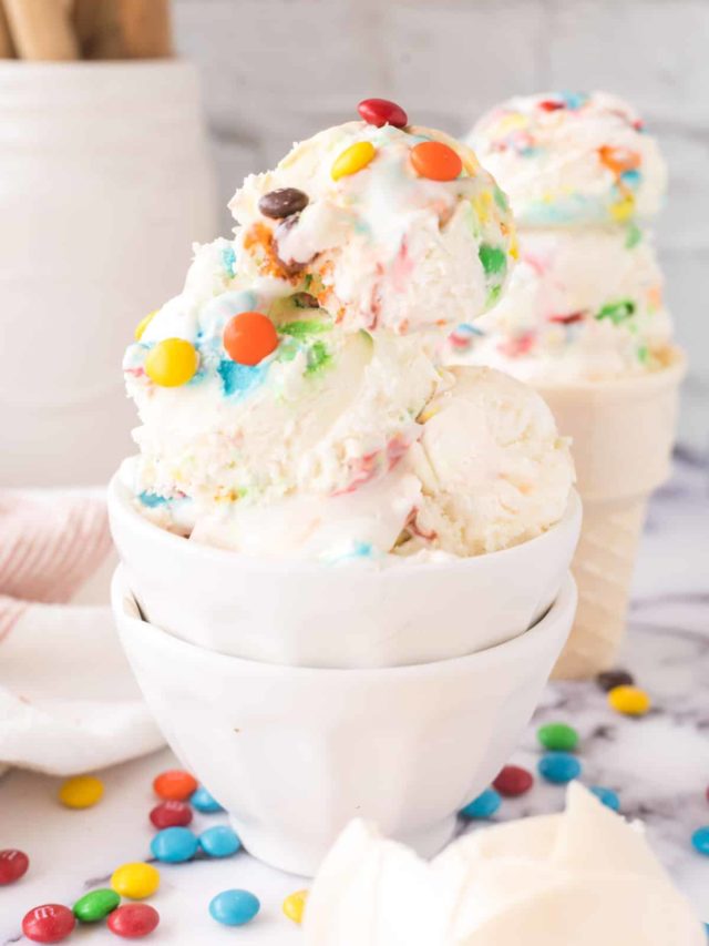 A white bowl filled with scoops of M&M ice cream.