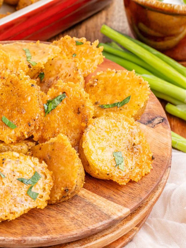 A plate filled with parmesan roasted potatoes garnished with parsley.