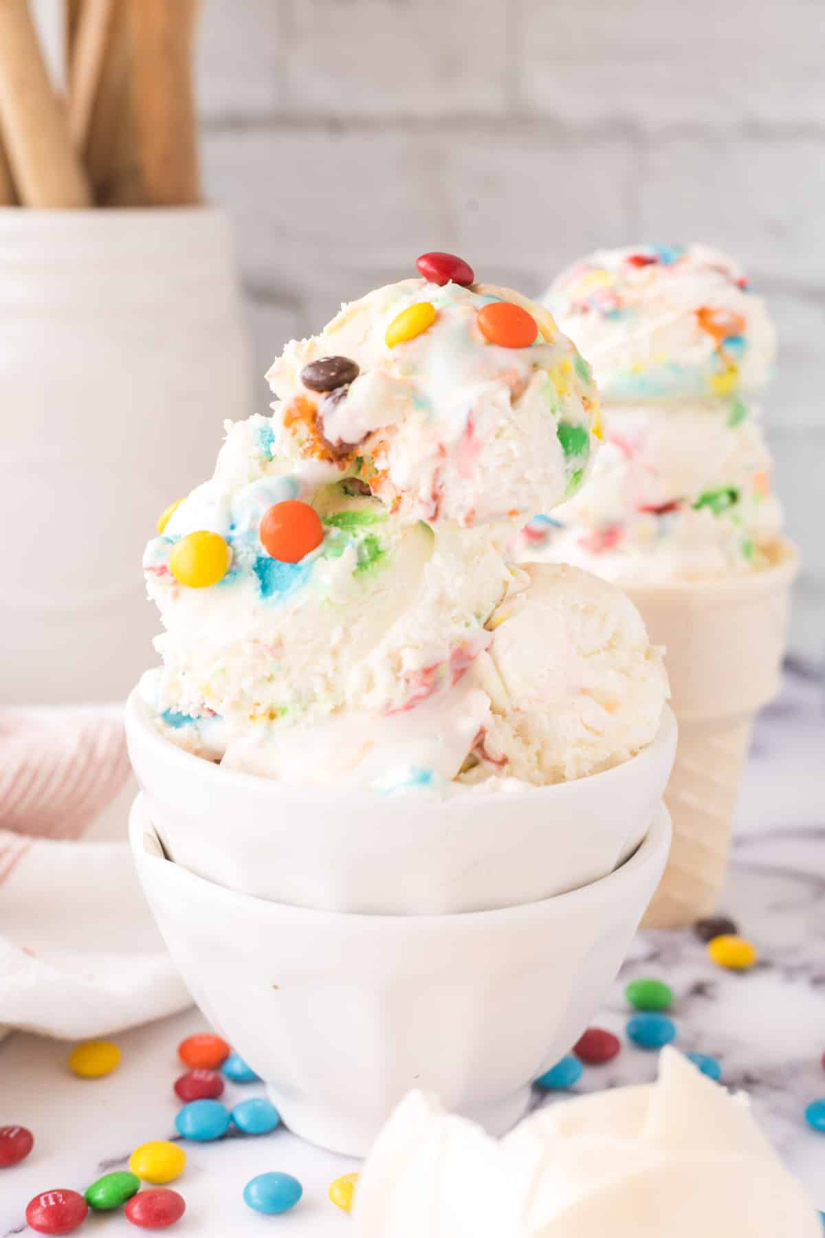 A white bowl filled with scoops of M&M ice cream.