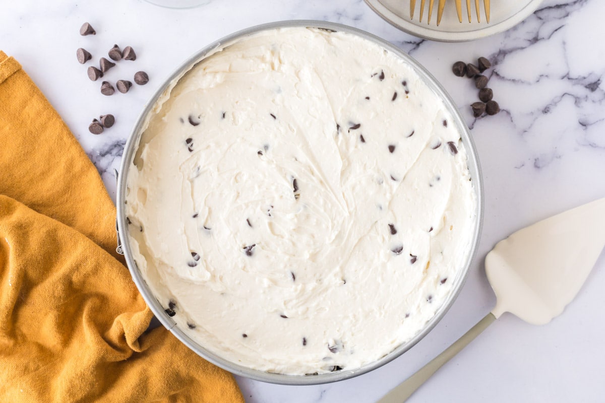 Cheese cake filling added to cookie dough crust in a spring form pan.