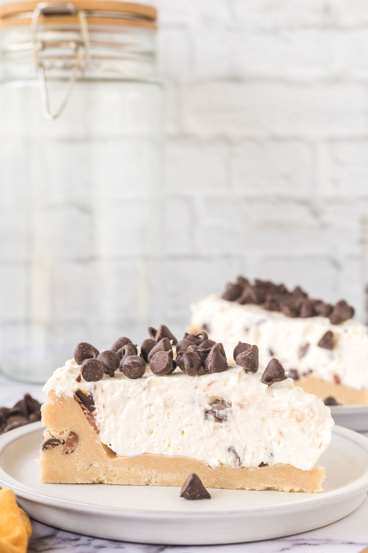 A slice of Cookie Dough Cheesecake topped with chocolate chips.
