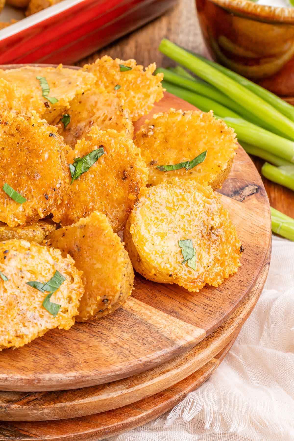 A plate filled with parmesan roasted potatoes garnished with parsley.