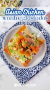 Looking from overhead, you see a white plate filled with the Asian Chicken Wonton Tostada and sitting on a decorative blue and white placemat.