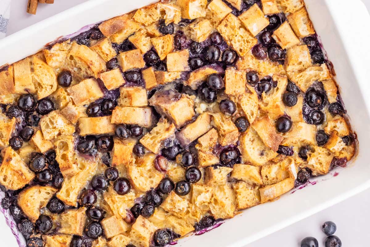 An up close overhead image of the blueberry french toast casserole in a white baking dish.