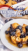 A plate filled with blueberry french toast casserole with maple syrup.