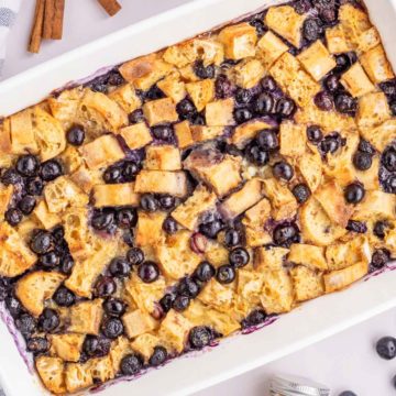 An up close overhead image of the blueberry french toast casserole in a white baking dish.