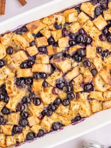 An up close overhead image of the blueberry french toast casserole in a white baking dish.