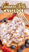 Cinnamon Roll Casserole is featured with a fork and topped with icing.