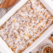 An iced cinnamon roll casserole in a white baking dish.