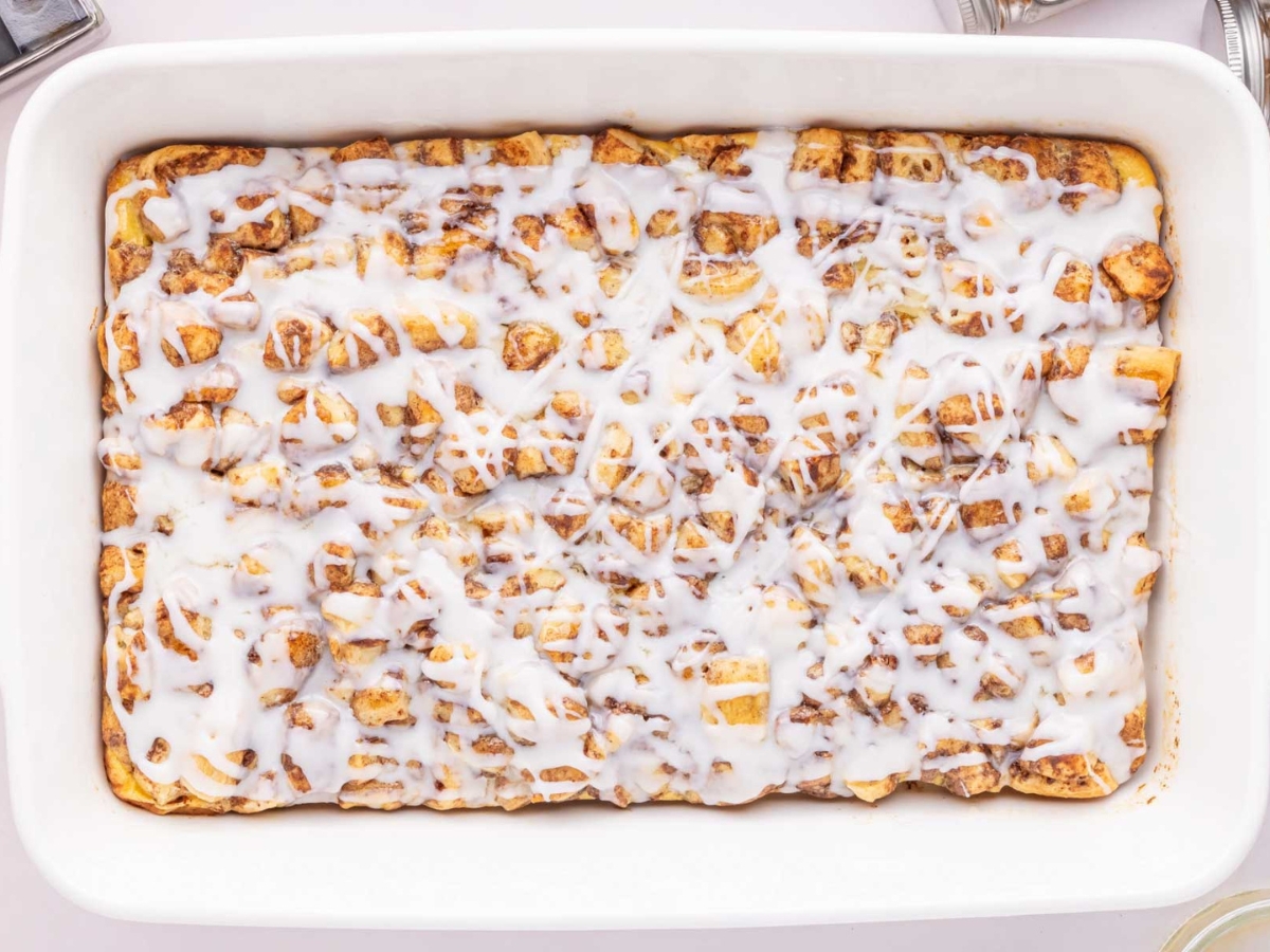 Baked cinnamon roll breakfast casserole with icing on top.