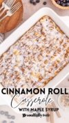 Cinnamon Roll Casserole with Maple Syrup is features in a white 9x13 baking dish topped with white icing.