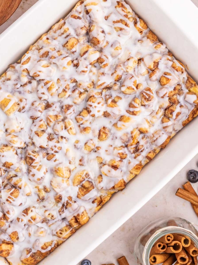 An iced cinnamon roll casserole in a white baking dish.