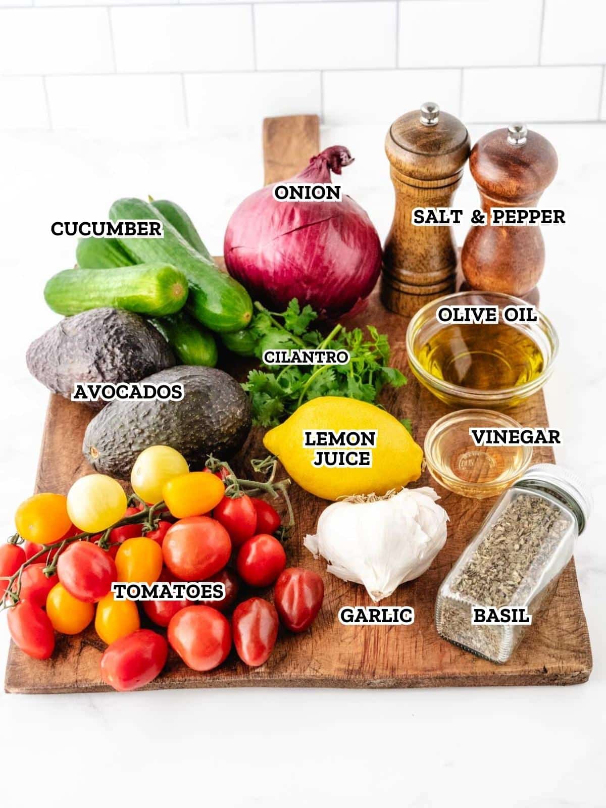 A labeled image of ingredients needed to make cucumber tomato avocado salad.