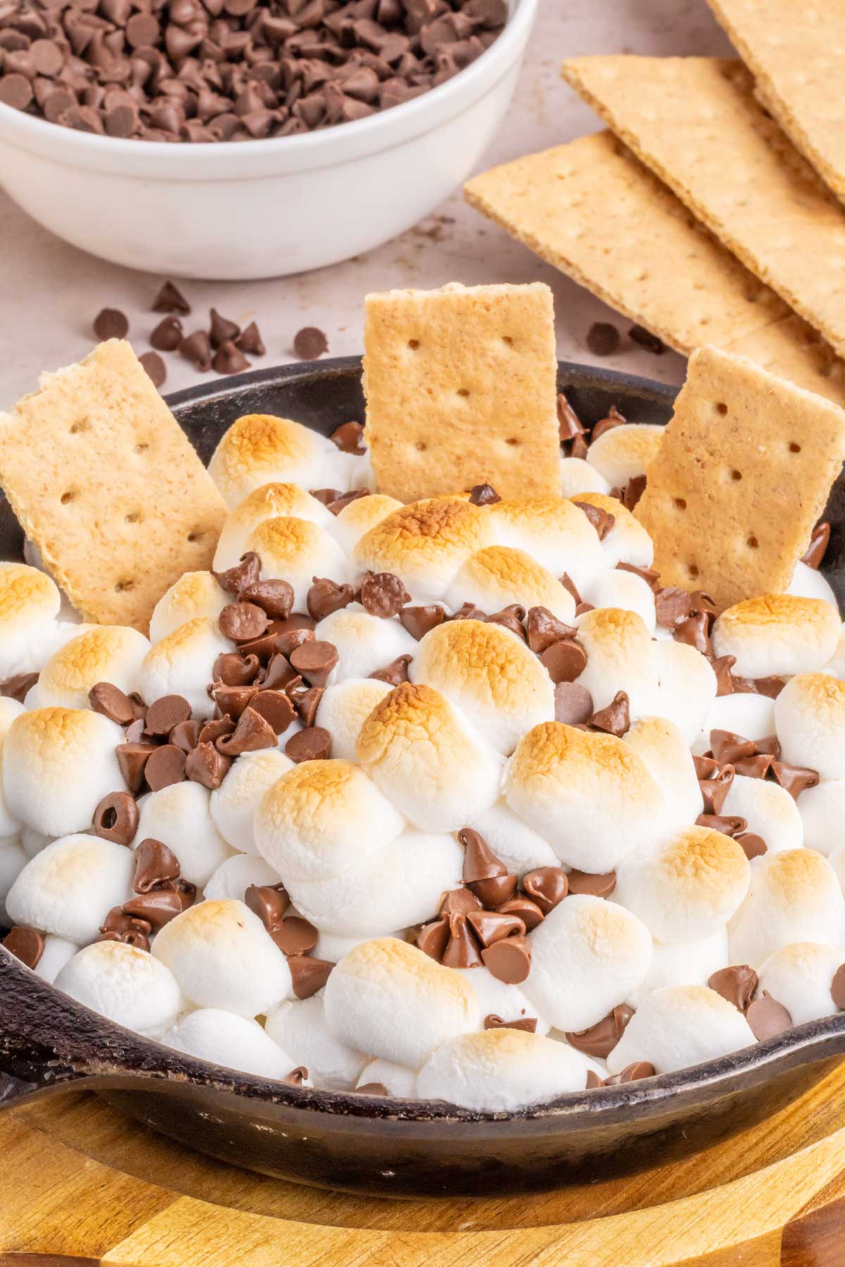 A melted s'mores dip with graham crackers displayed dipped into the skillet.