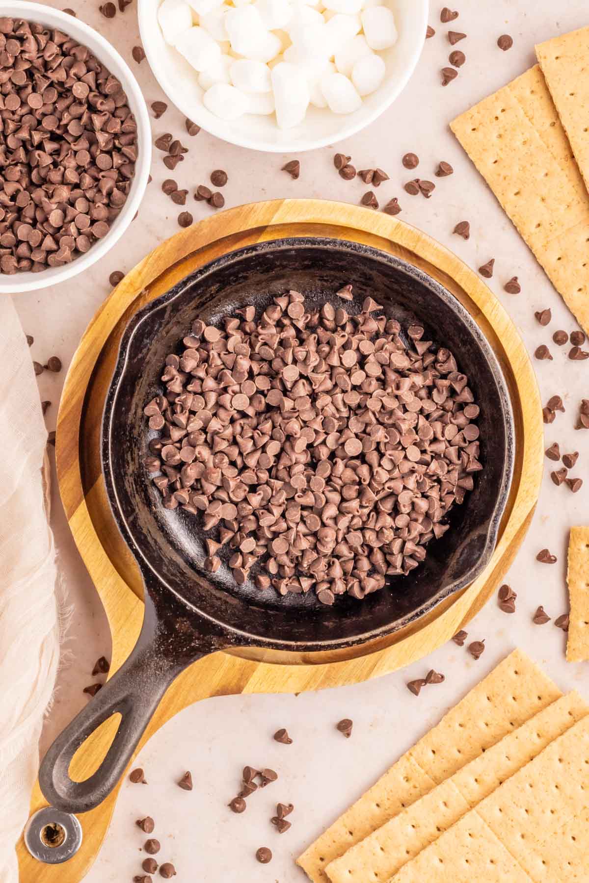 Chocolate chips added to a cast iron skillet.