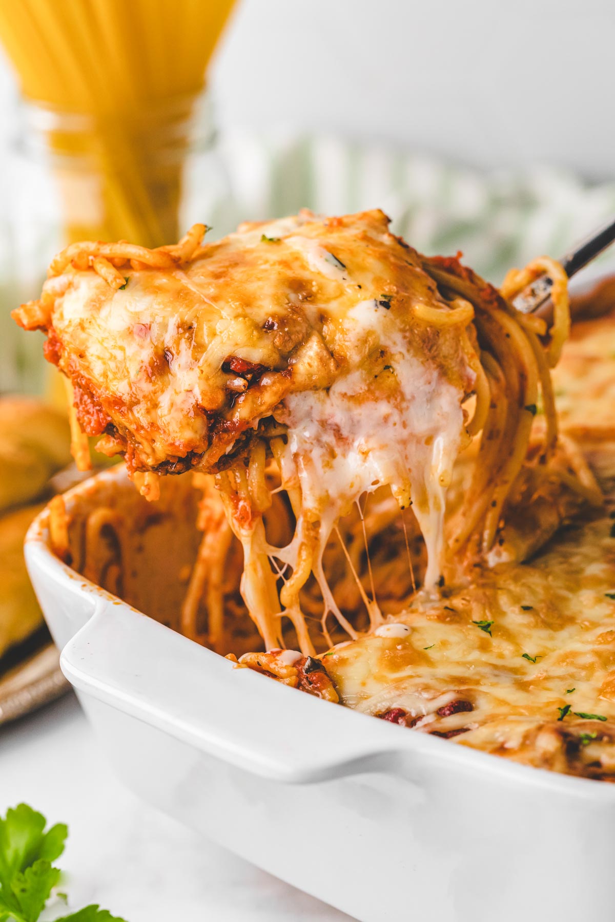 Removing a scoop of layered baked spaghetti with a spatula.