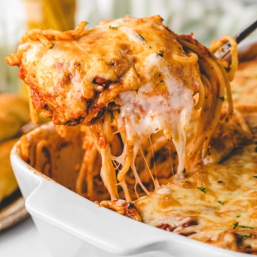 Removing a scoop of layered baked spaghetti with a spatula