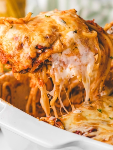Removing a scoop of layered baked spaghetti with a spatula