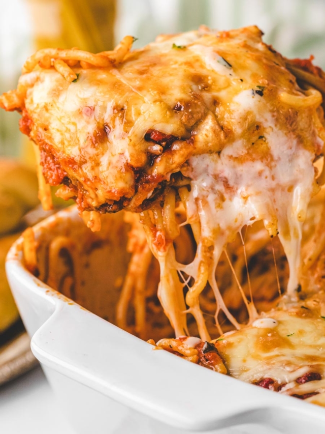 Removing a scoop of layered baked spaghetti with a spatula