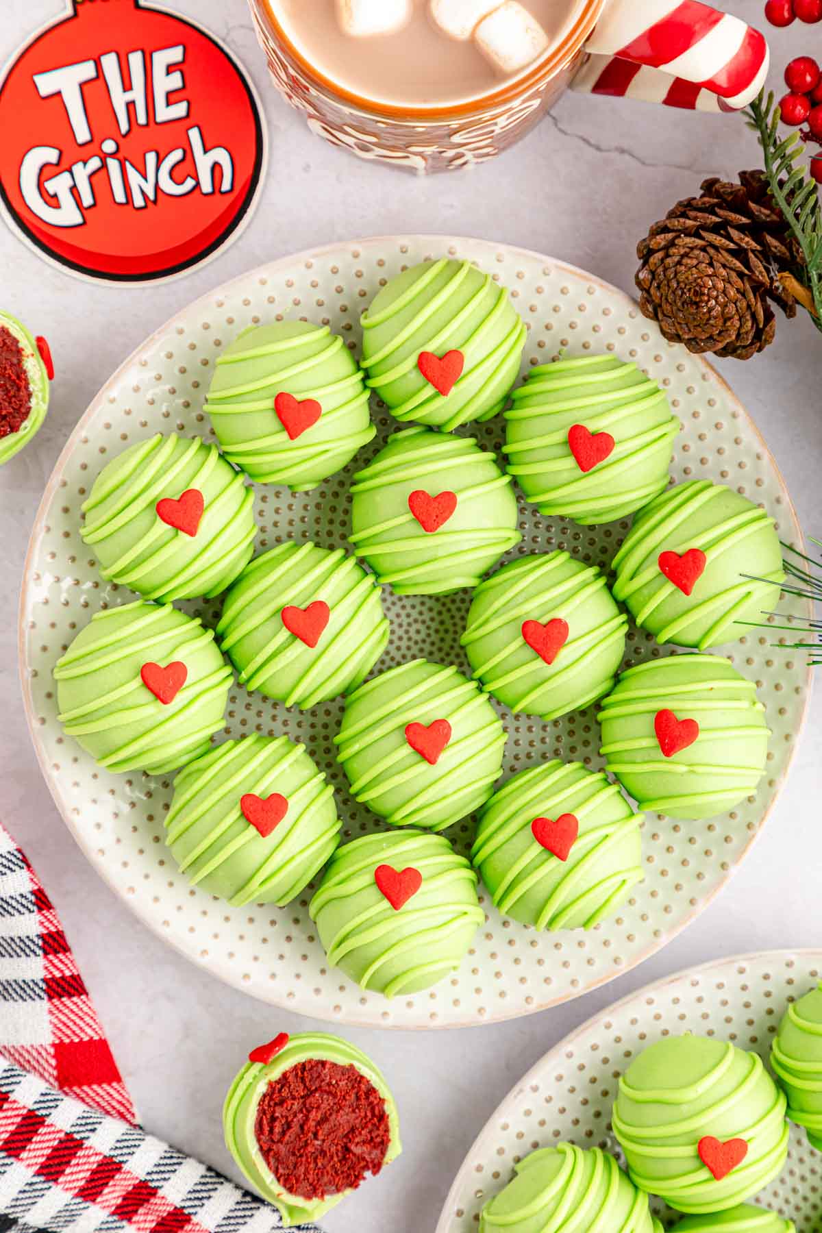 Grinch red velvet Oreo Balls set on a pattered plate on a Grinch themed tablescape.