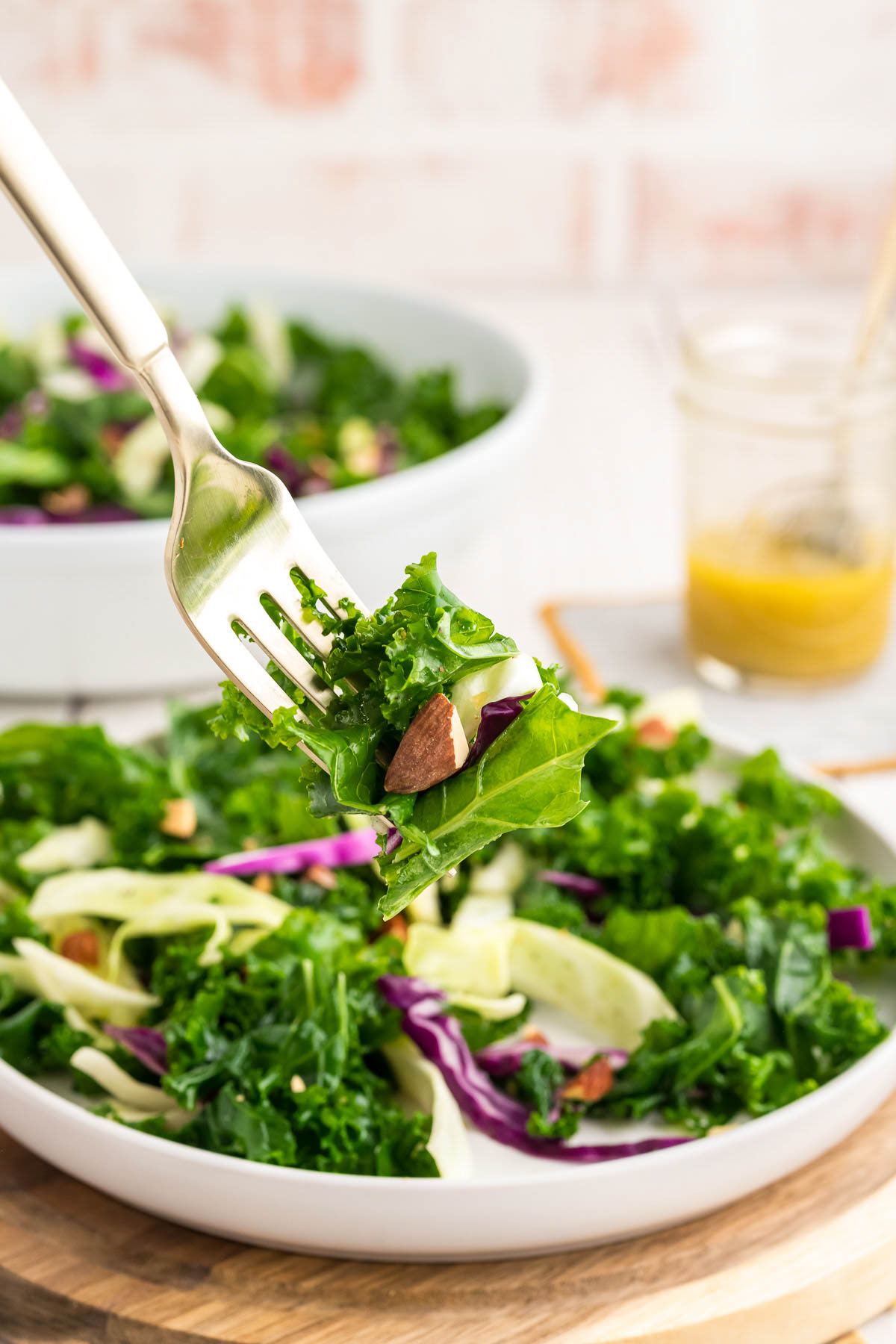 A fork removing a bite of kale salad.